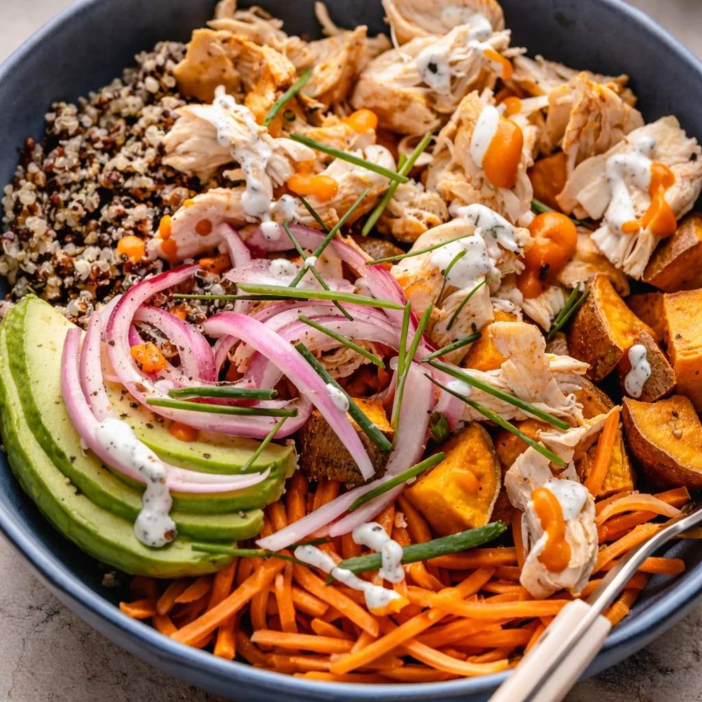 Colorful Buffalo Chicken Bowl with chicken, vegetables, rice, and ranch dressing.