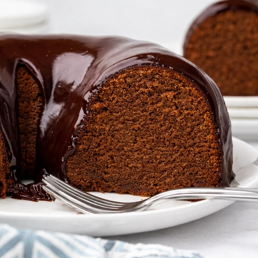 Slice of rich Chocolate Pound Cake topped with a glossy chocolate glaze.