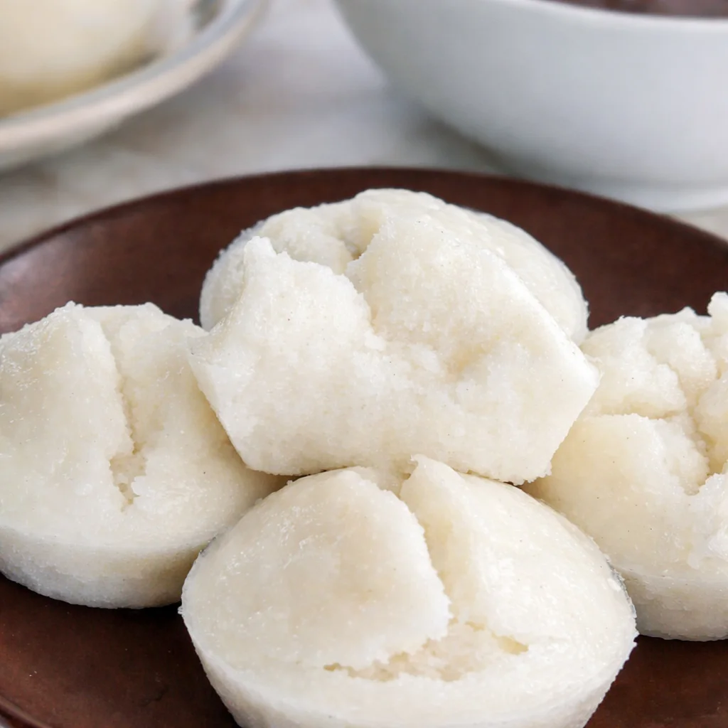 Fluffy Steamed Rice Cakes (Puto Bigas) served on a plate, showcasing their soft texture.