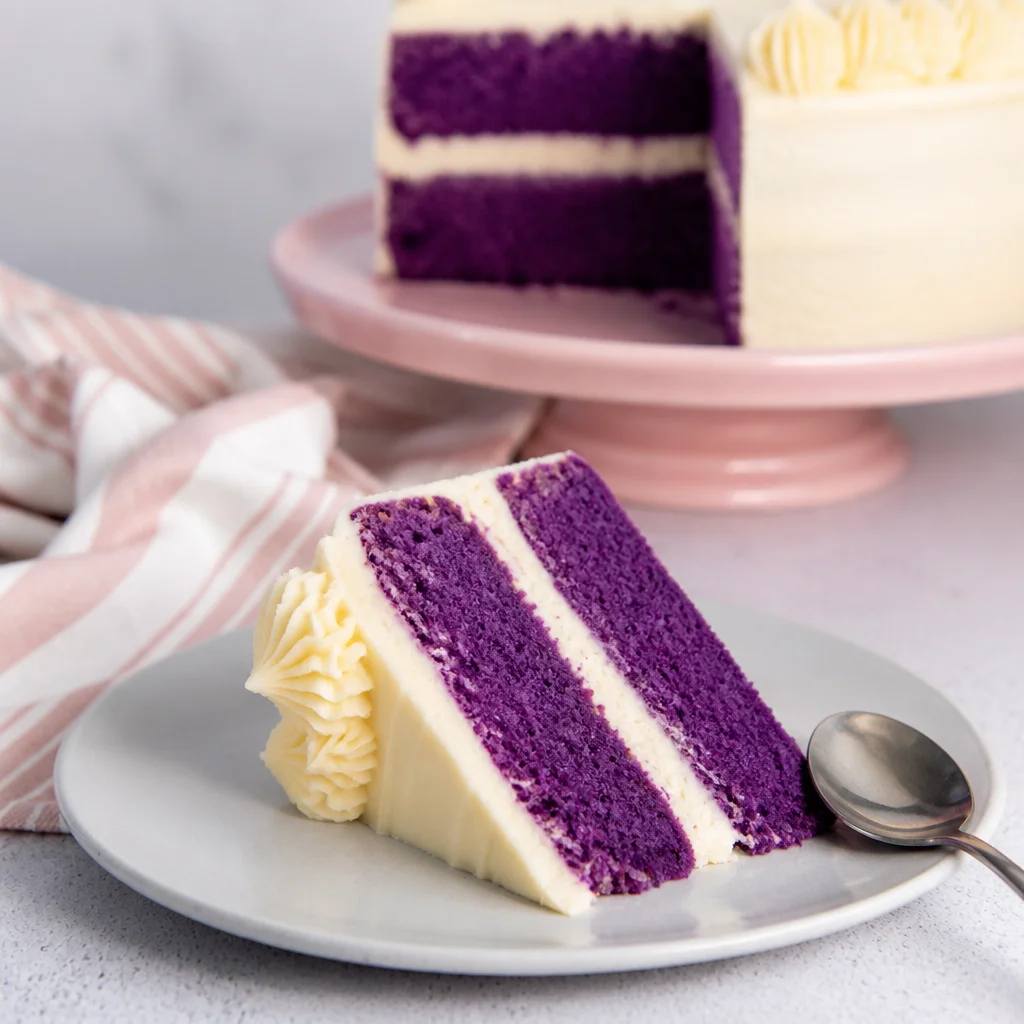 Delicious Purple Velvet Cake with Cream Cheese Frosting topped with colorful sprinkles.