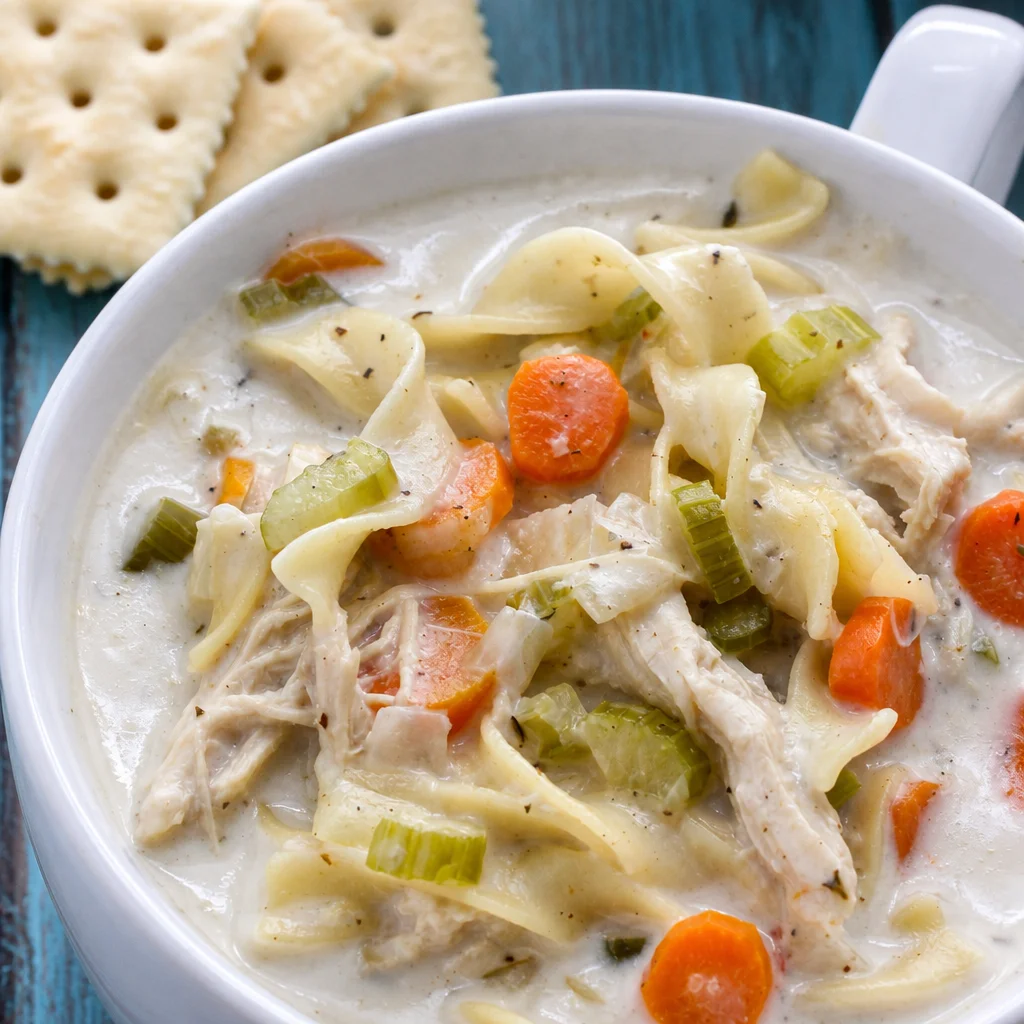 Bowl of Slow Cooker Creamy Chicken Noodle Soup with chicken, carrots, and noodles