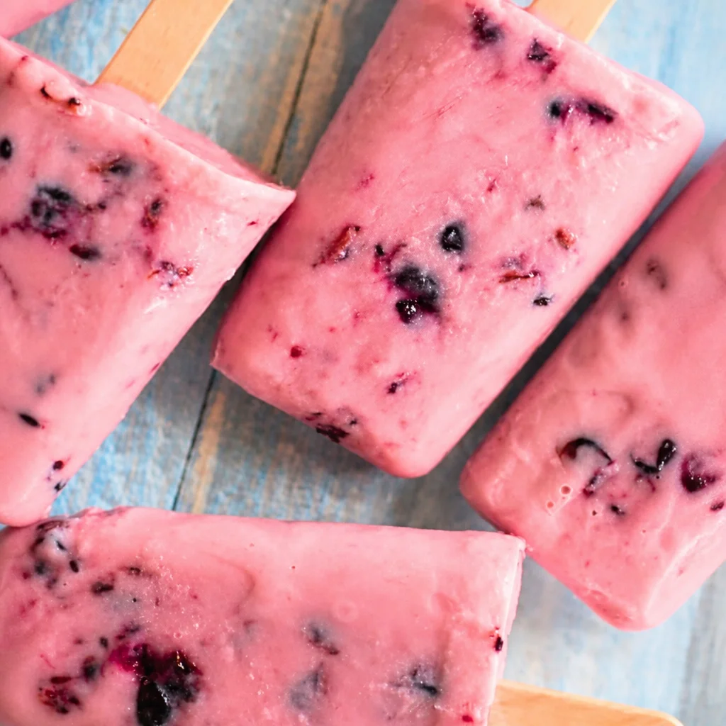 Colorful homemade Greek Yogurt Popsicles with berries and honey.