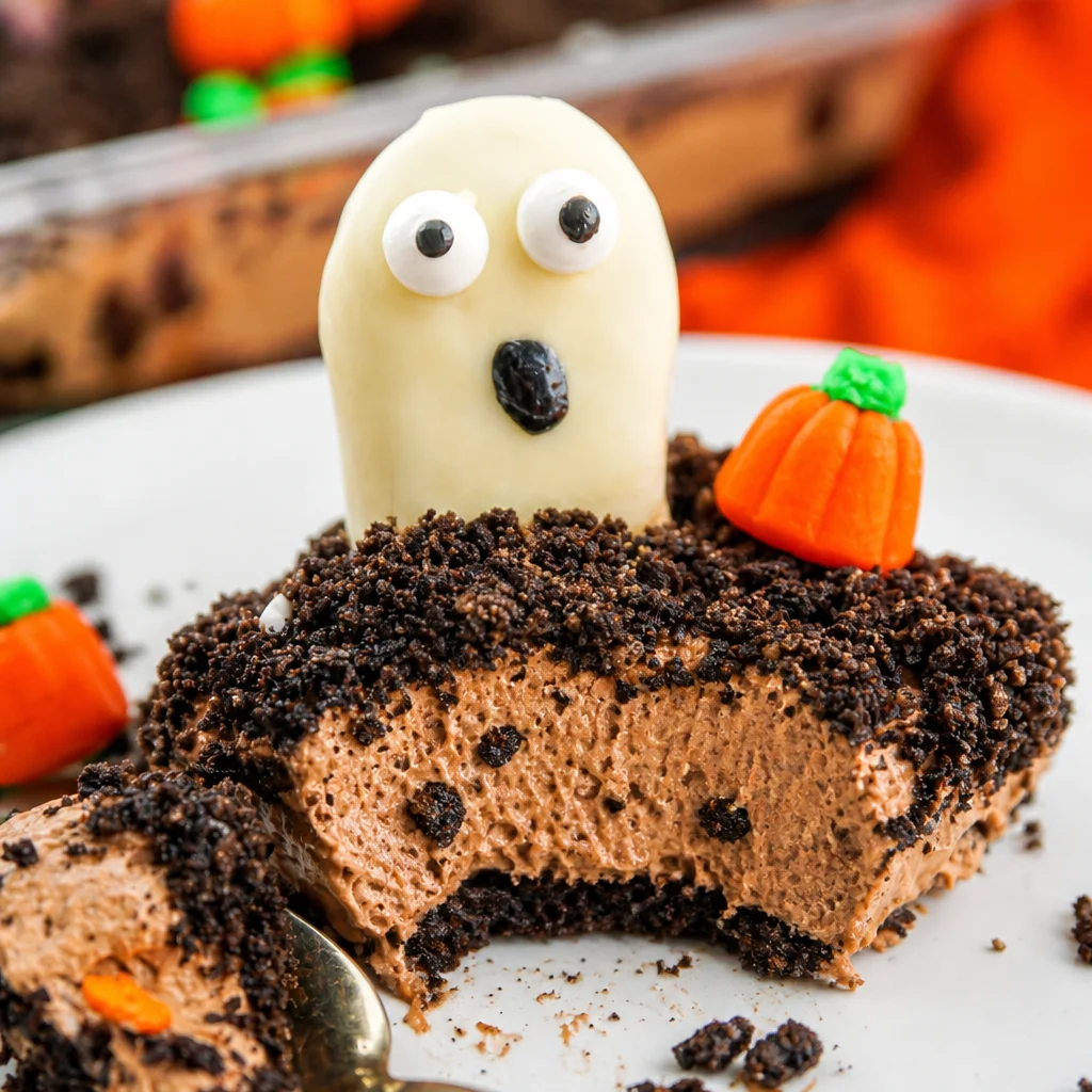 Delicious Halloween dirt cake with layers of Oreo, chocolate pudding, and cream cheese.